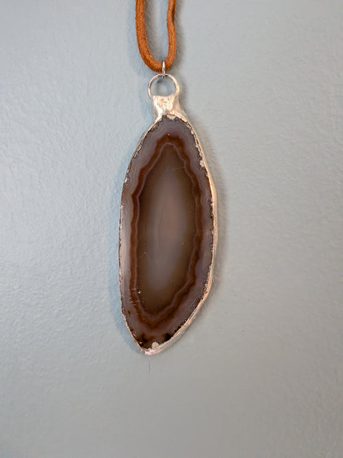 Necklace No. 002: front close-up of the banded agate, handmade silver-tone edging and light brown cord.