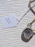 Front of Silver Mist Banded necklace No. 011, showing its natural stone pattern, handmade silver-tone edge, and tan cord.