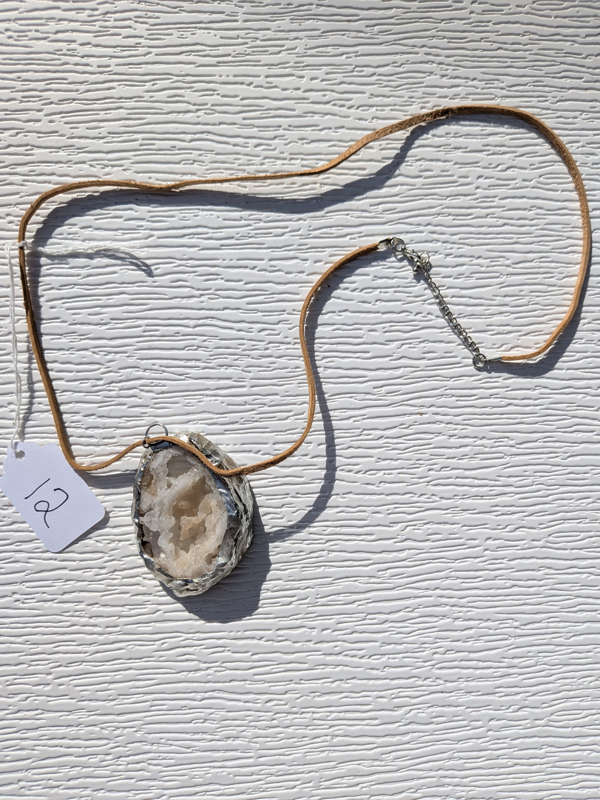 Full Honey Crystal Cavern geode necklace No. 012, showing the pendant, tan cord, and clasp.