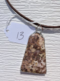 Front of Earth Mosaic necklace No. 013, showing its natural stone pattern, handmade silver-tone edge, and dark brown cord.