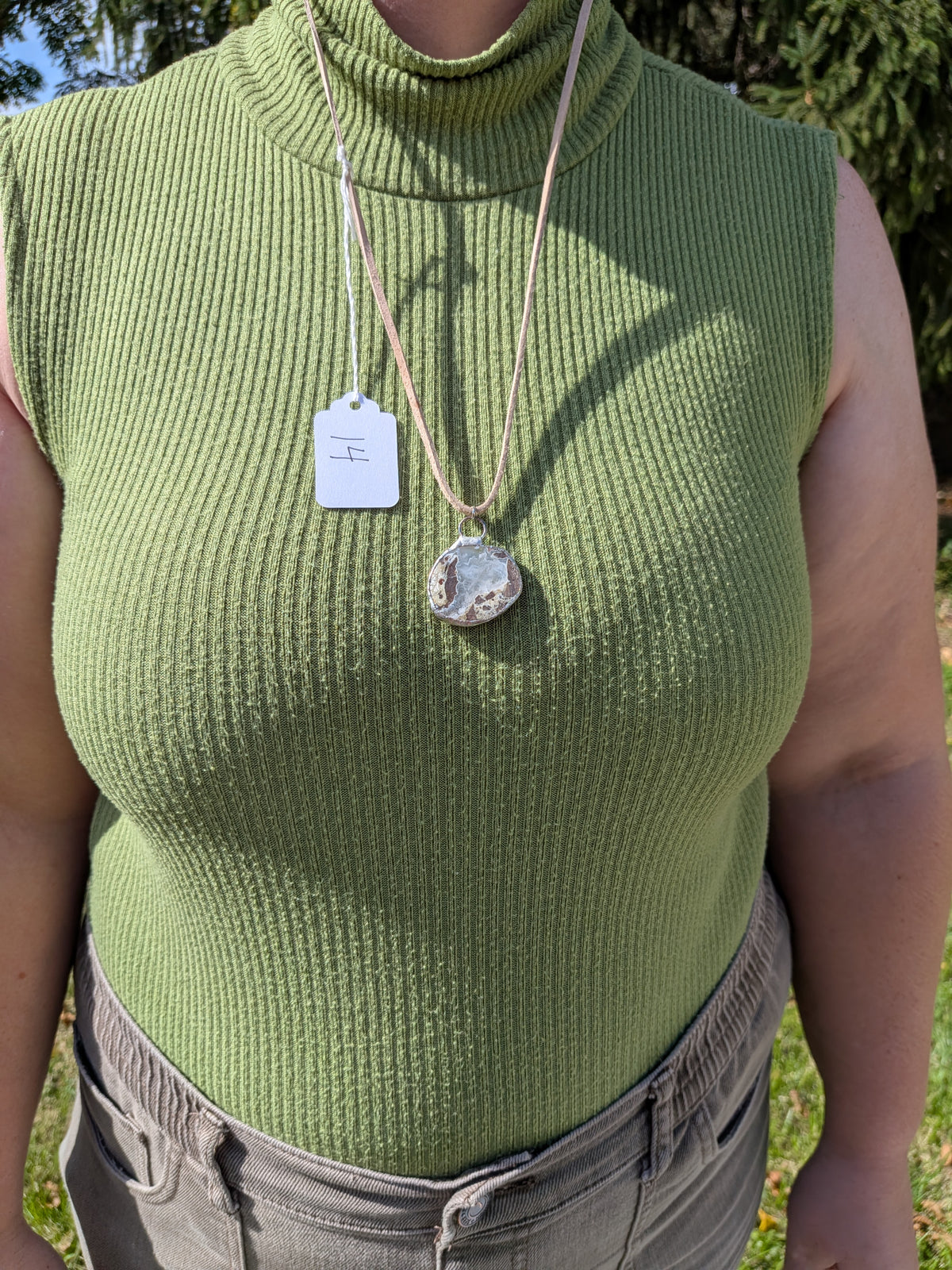 Cloud Meadow necklace No. 014 worn on the body, showing the pendant's proportions and tan cord.