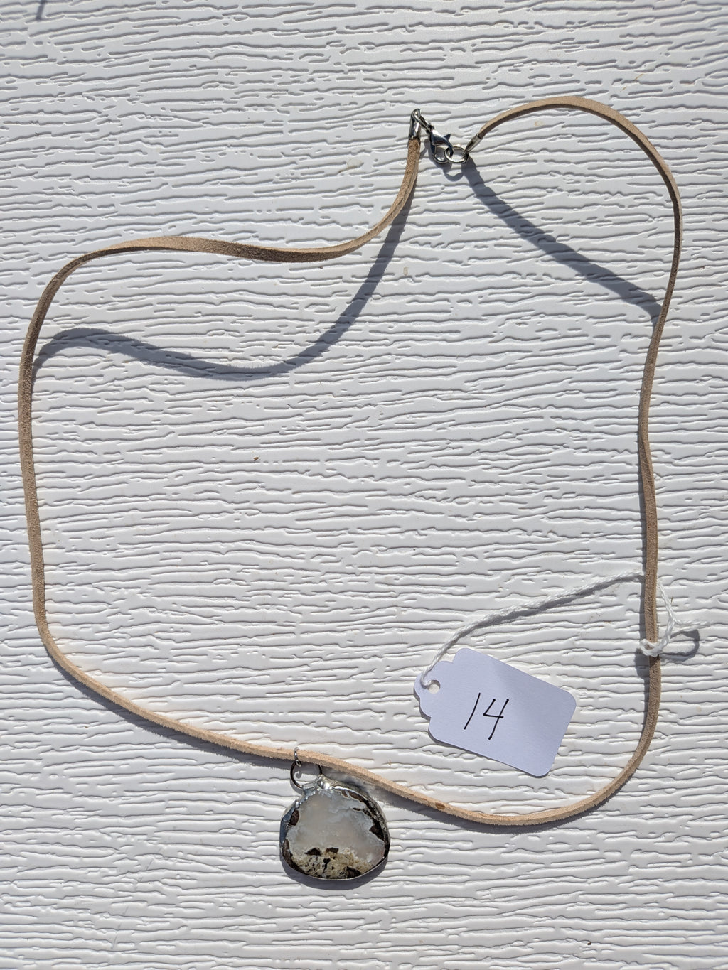 Full Cloud Meadow necklace No. 014, showing the pendant, tan cord, and clasp.