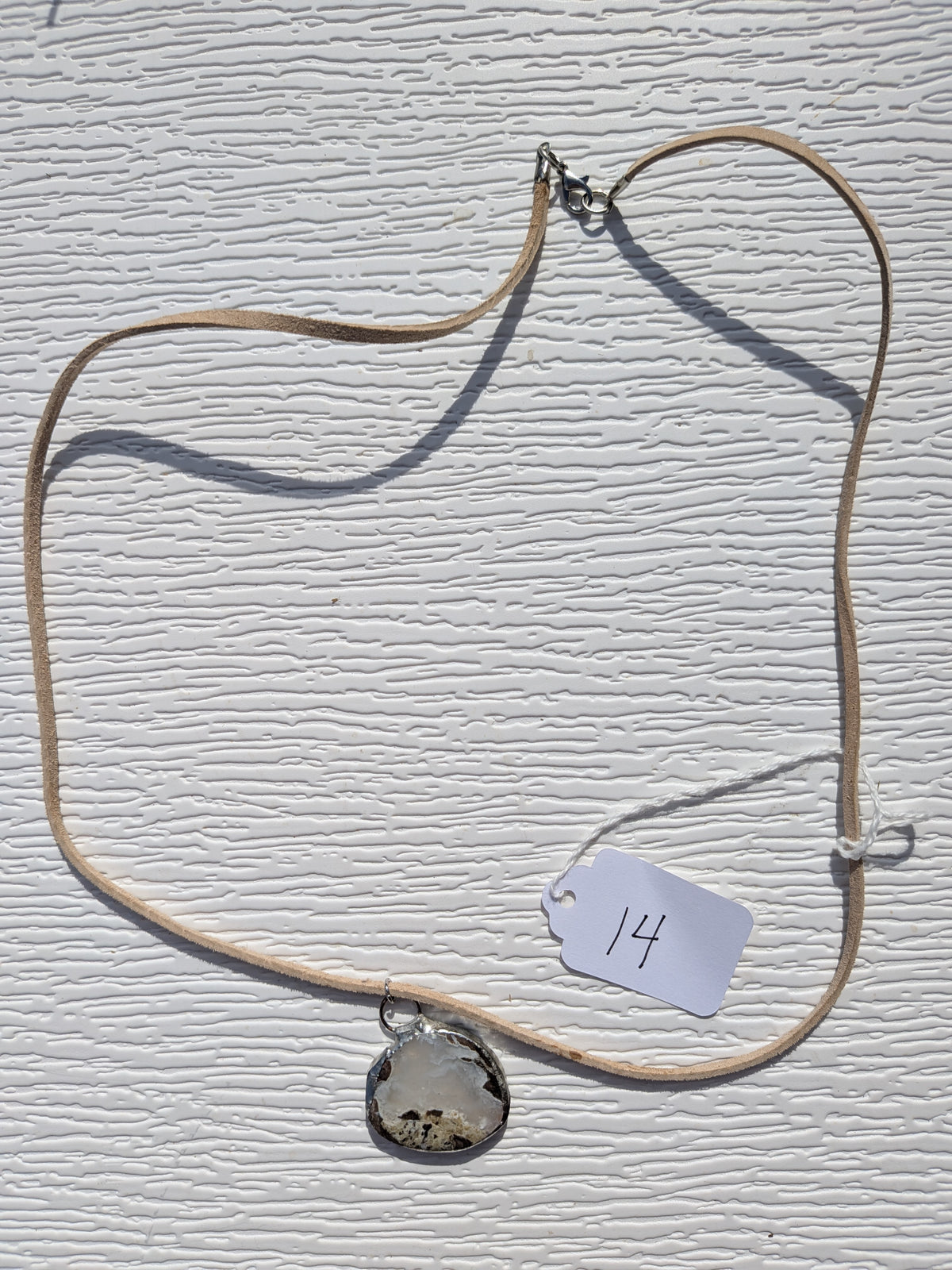 Full Cloud Meadow necklace No. 014, showing the pendant, tan cord, and clasp.