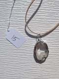 Front of Crystal Pool necklace No. 015, showing its natural stone pattern, handmade silver-tone edge, and tan cord.