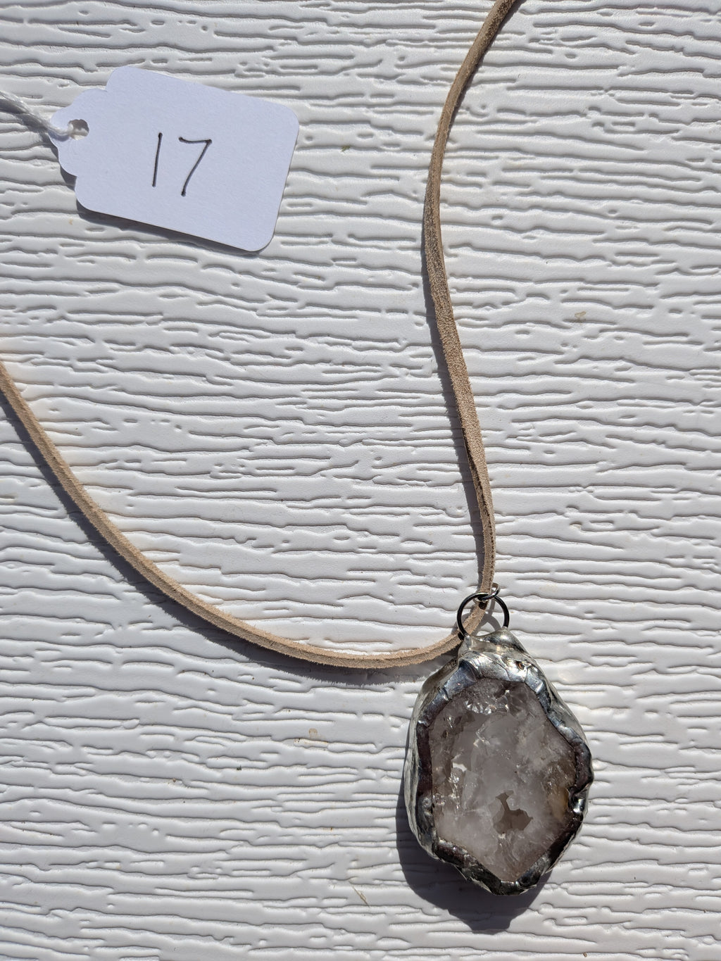 Front of Smoky Frost necklace No. 017, showing its natural stone pattern, handmade silver-tone edge, and tan cord.