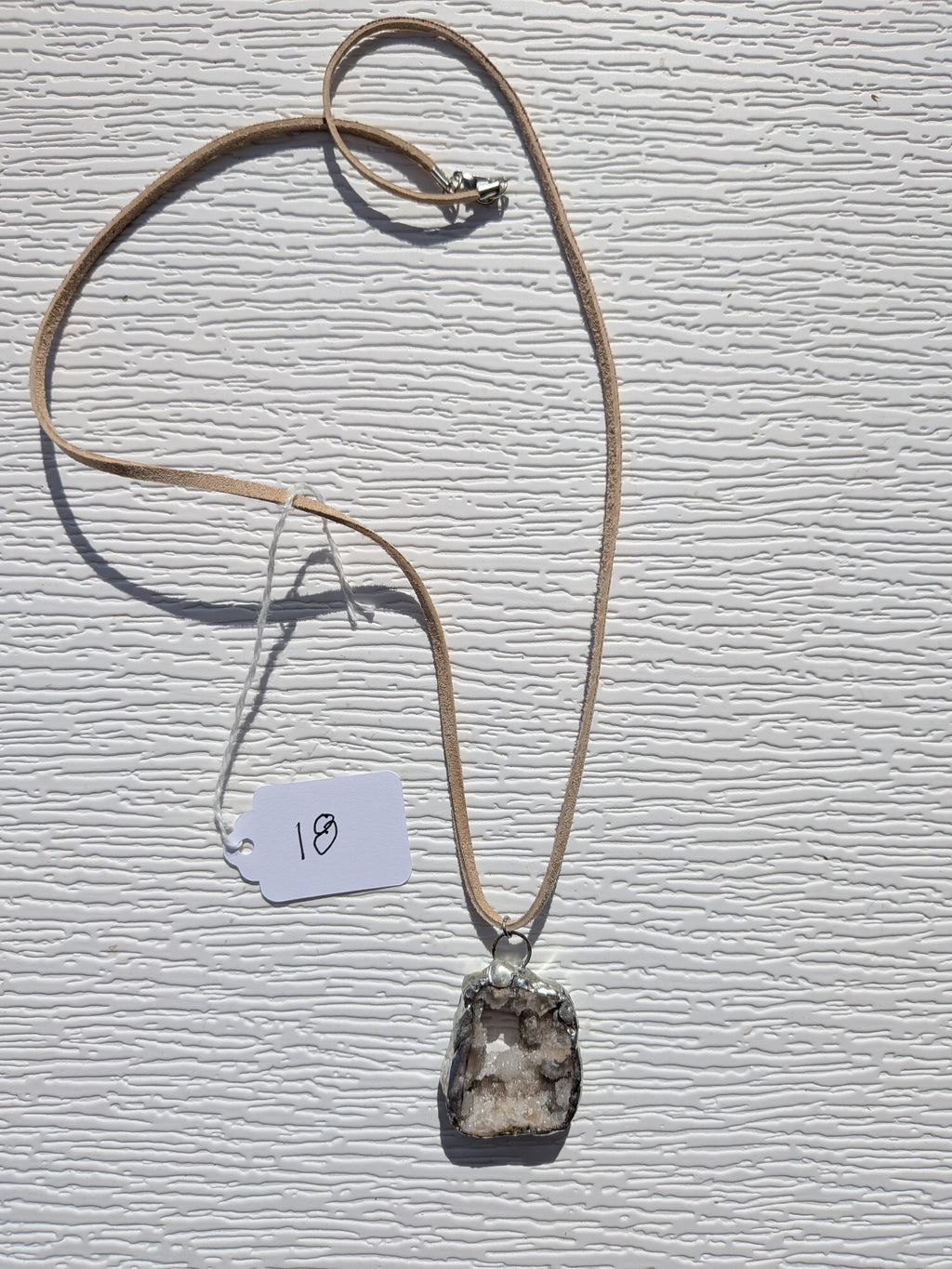 Full Crystal Grotto necklace No. 018, showing the pendant, tan cord, and clasp.