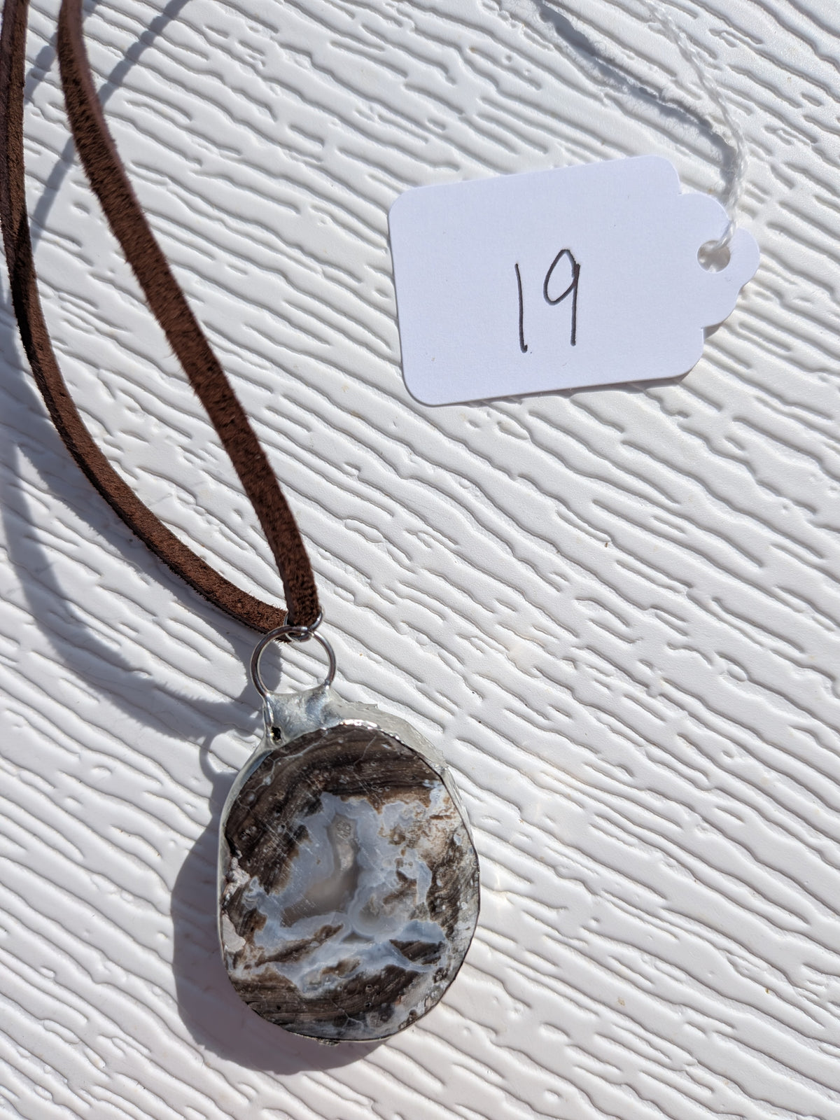 Back of Storm Crystal Cavern necklace No. 019, showing the natural stone contours and handmade silver-tone edge.
