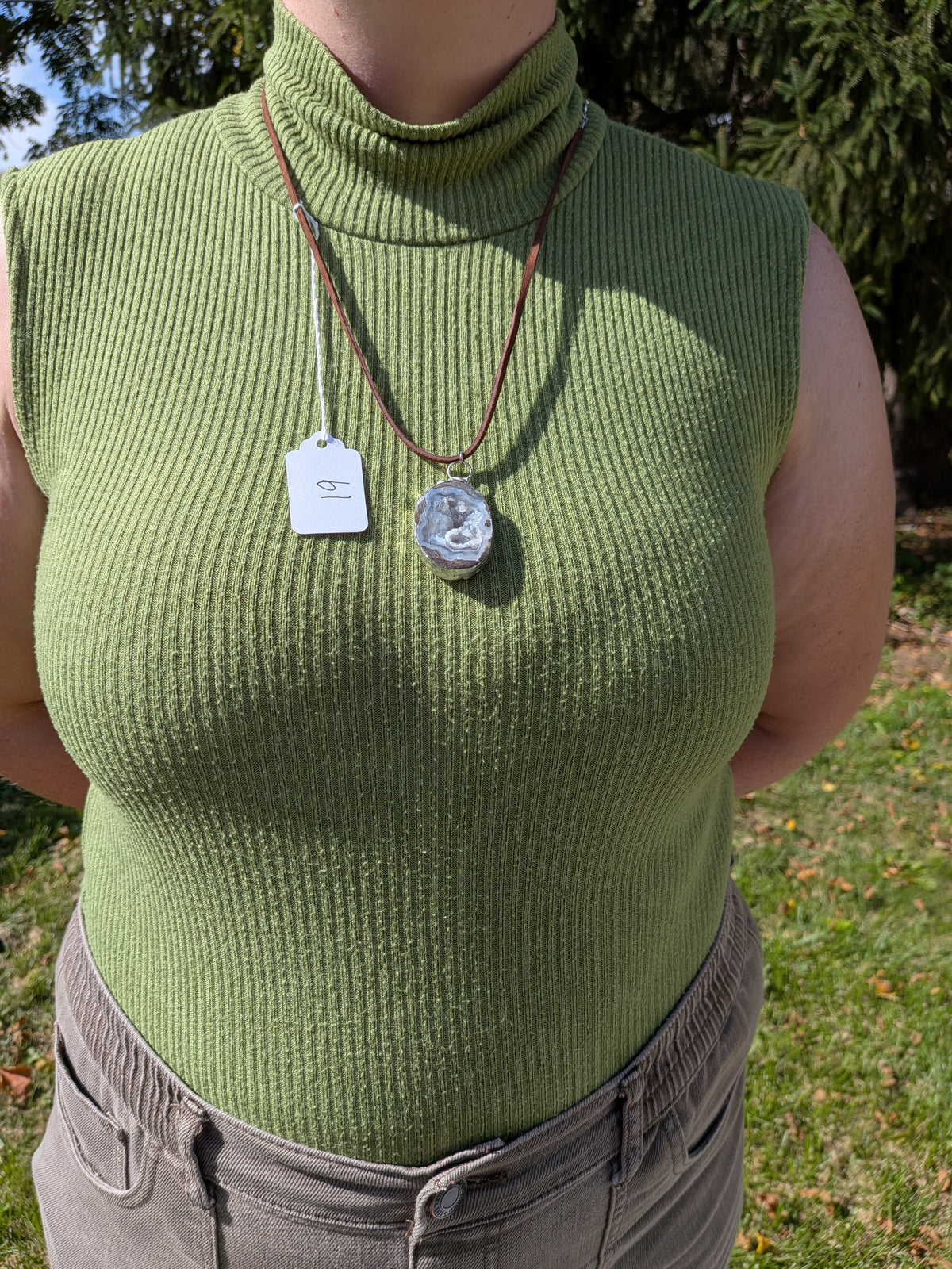Storm Crystal Cavern necklace No. 019 worn on the body, showing the pendant's proportions and dark brown cord.