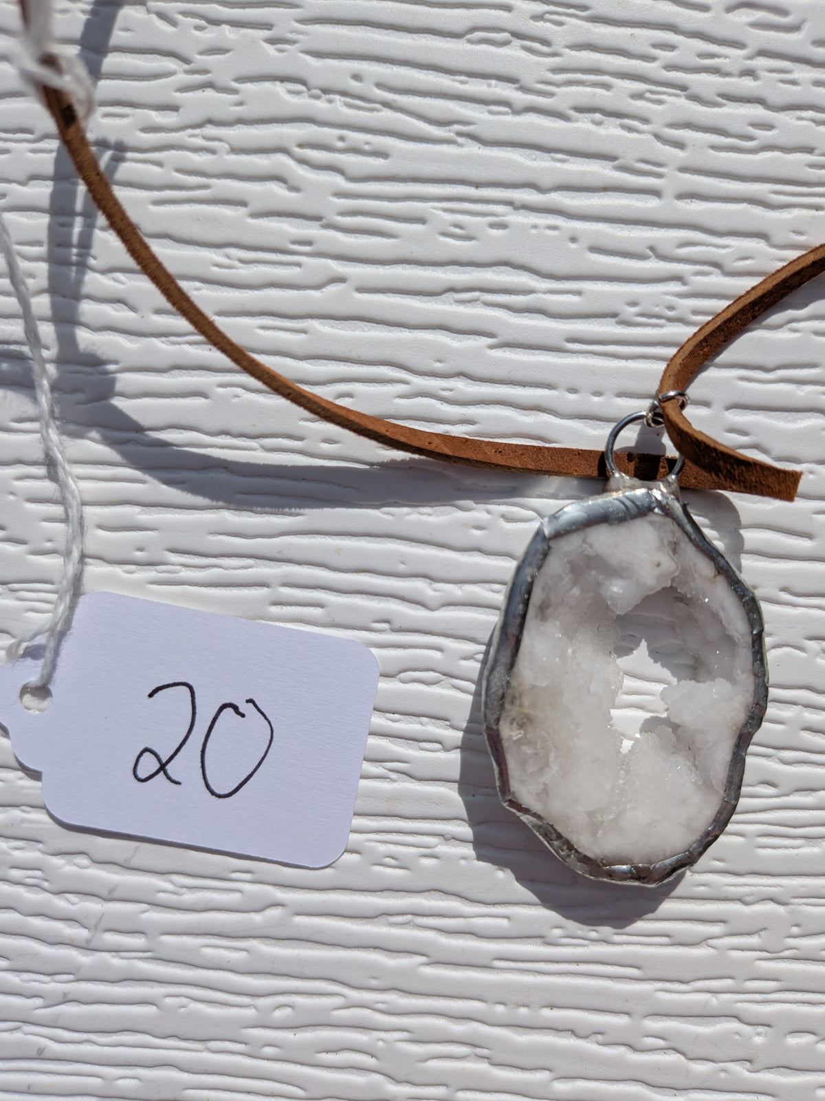 Back of Snowlight Window necklace No. 020, showing the natural stone contours and handmade silver-tone edge.
