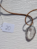 Front of Snowlight Window necklace No. 020, showing its natural stone pattern, handmade silver-tone edge, and warm brown cord.