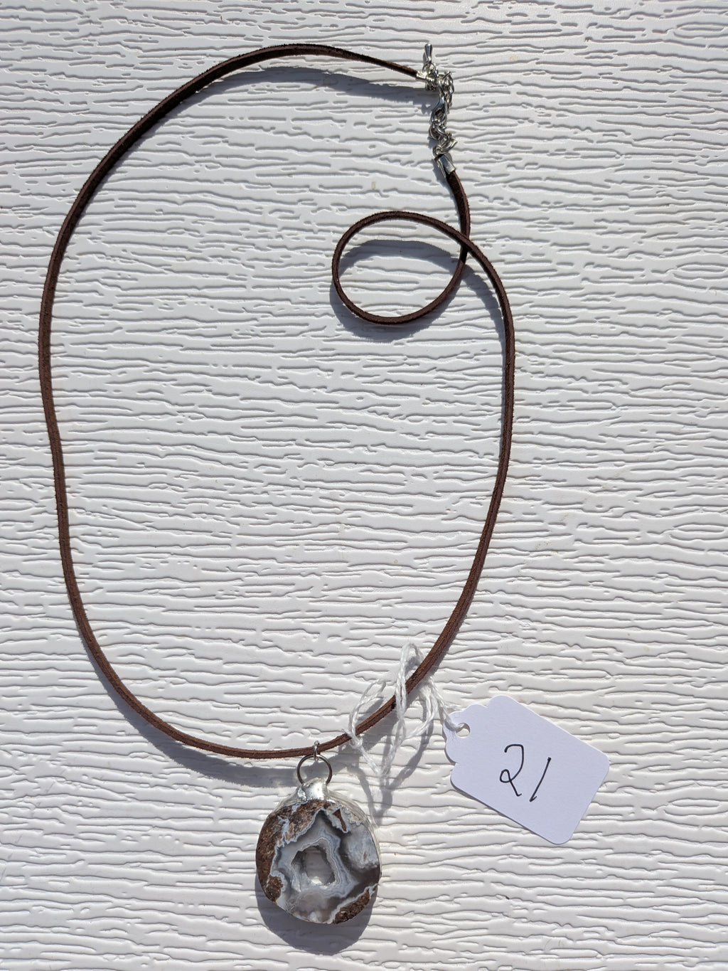 Full Mountain Hollow necklace No. 021, showing the pendant, dark brown cord, and clasp.