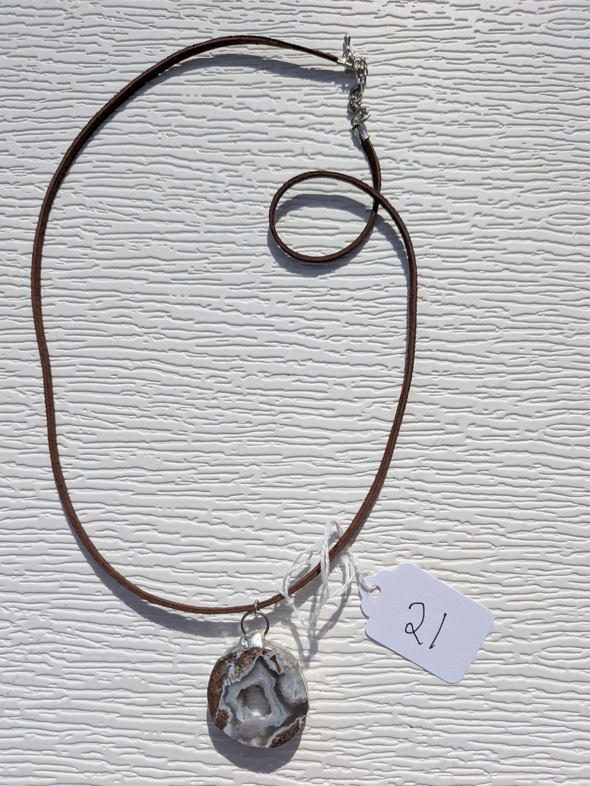Full Mountain Hollow necklace No. 021, showing the pendant, dark brown cord, and clasp.
