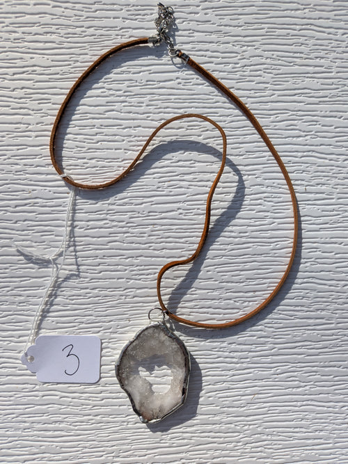 Full Crystal Window geode necklace No. 003, showing the open white and gray pendant, tan cord, clasp, and extension chain.