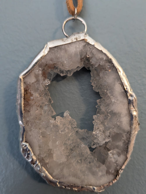 Necklace No. 004: front close-up of the white geode, natural stone detail and handmade silver-tone edging.