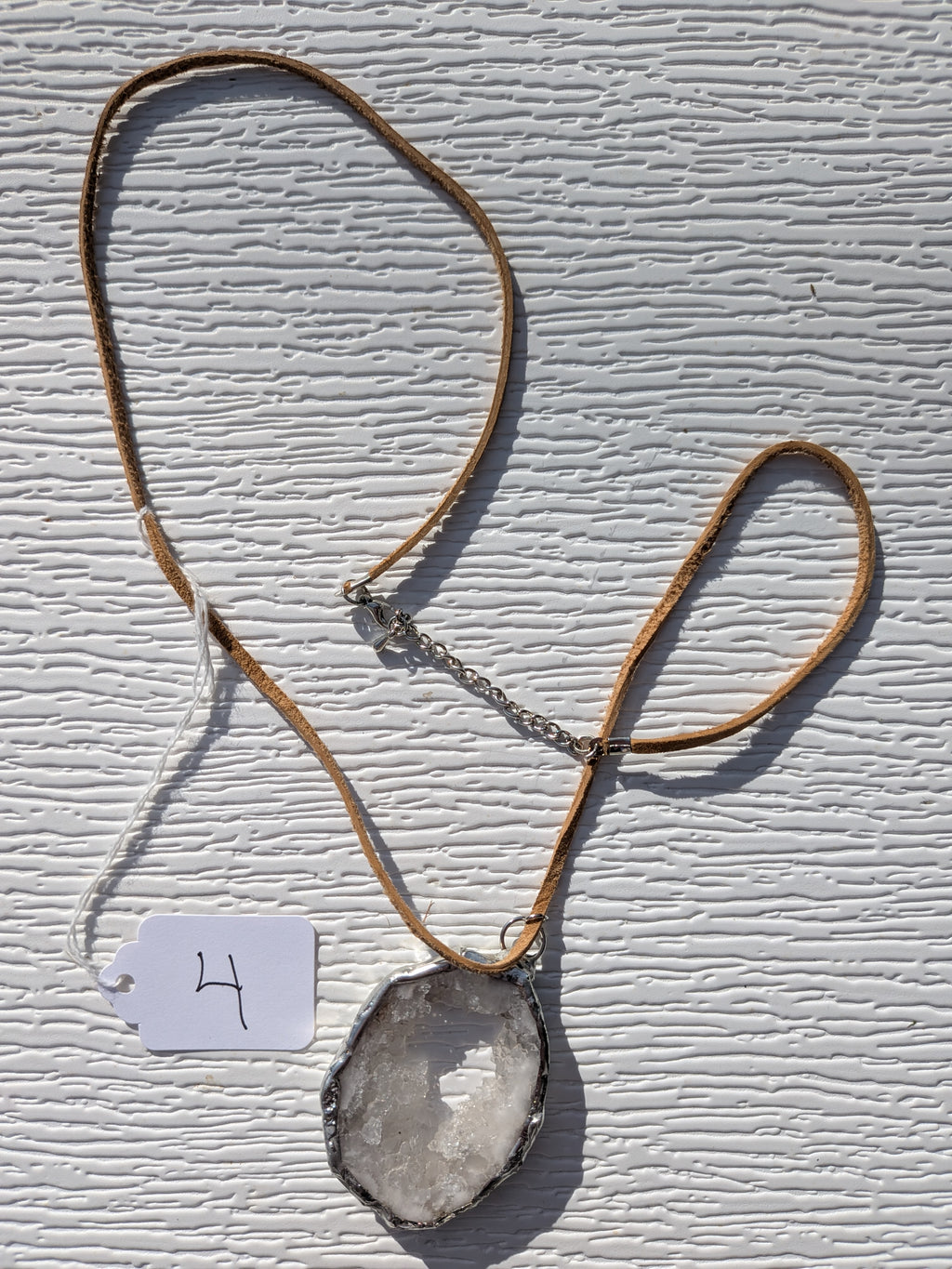 Full Frosted Halo geode necklace No. 004, showing the pendant, tan cord, and clasp.