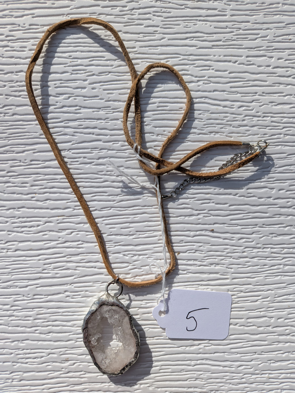 Full Dewdrop Window geode necklace No. 005, showing the pendant, tan cord, and clasp.