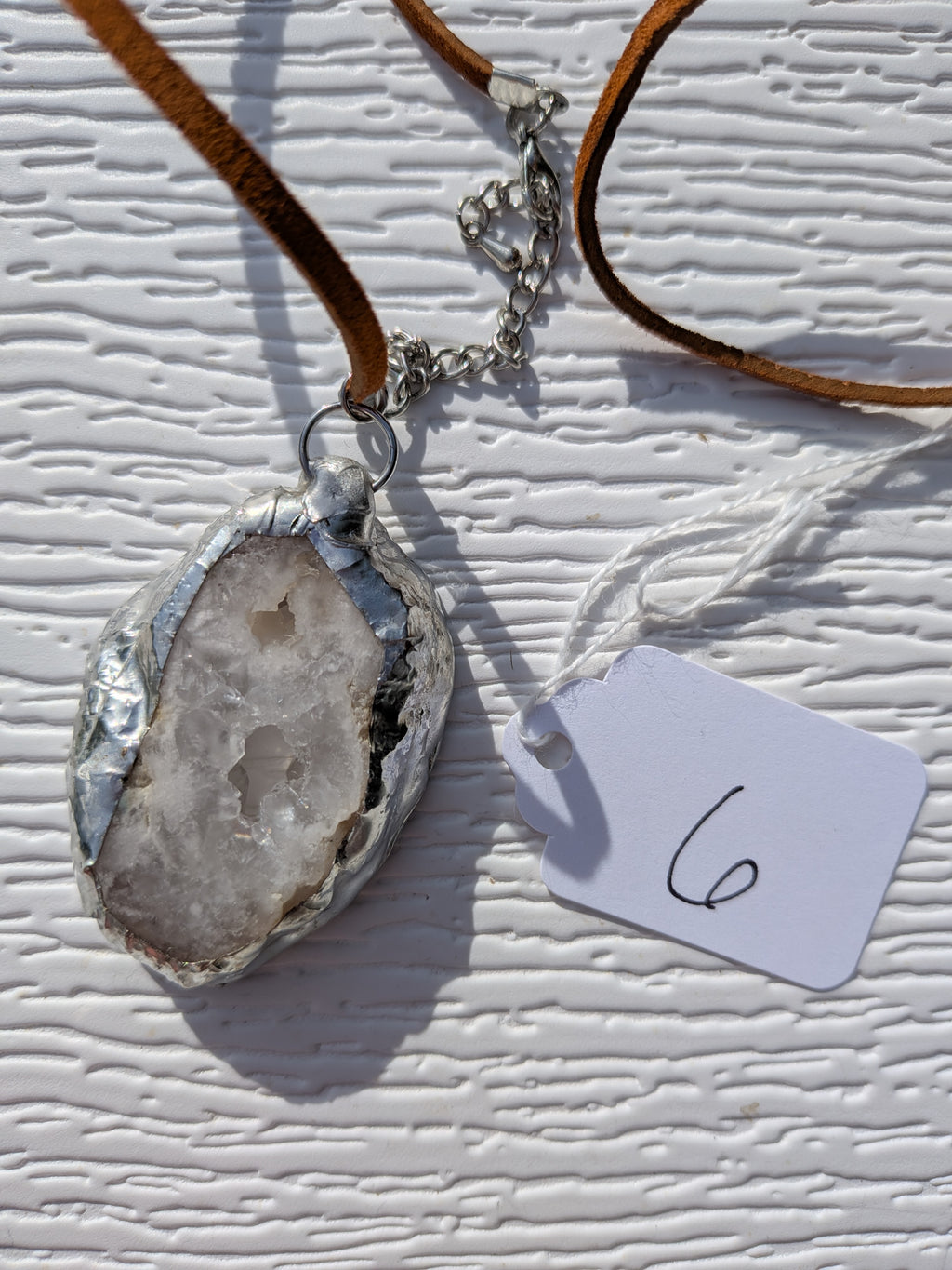 Back of Frosted Crystal geode necklace No. 006, showing the natural stone contours and handmade silver-tone edge.