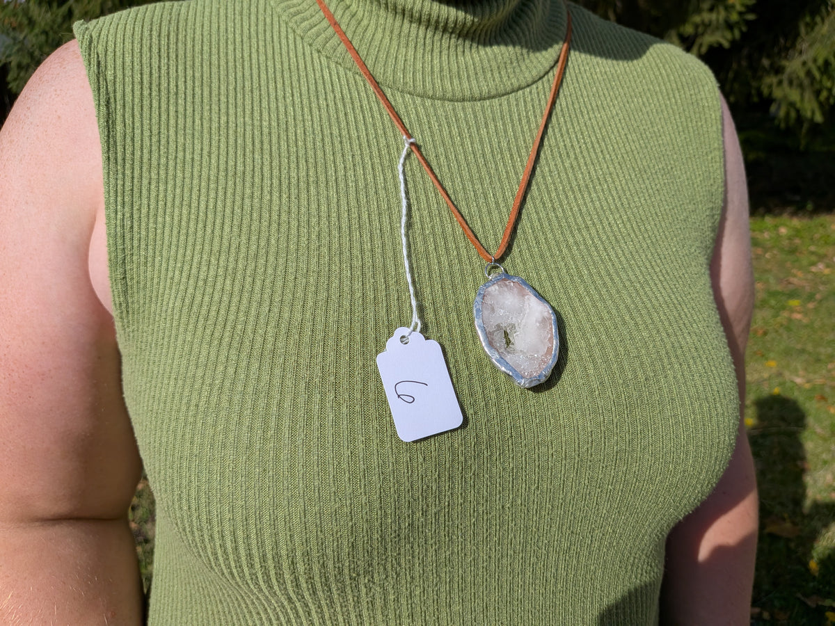 Frosted Crystal geode necklace No. 006 worn over a green top, showing the pendant’s proportions and brown cord.
