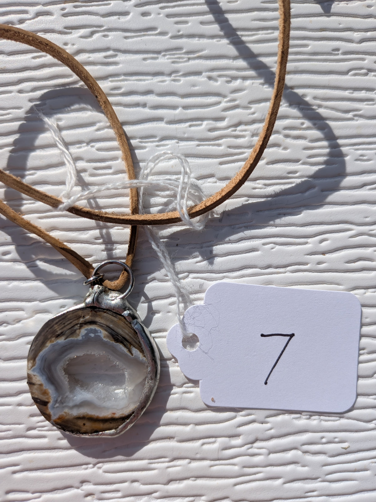 Back of Earth Rings geode necklace No. 007, showing the natural stone contours and handmade silver-tone edge.