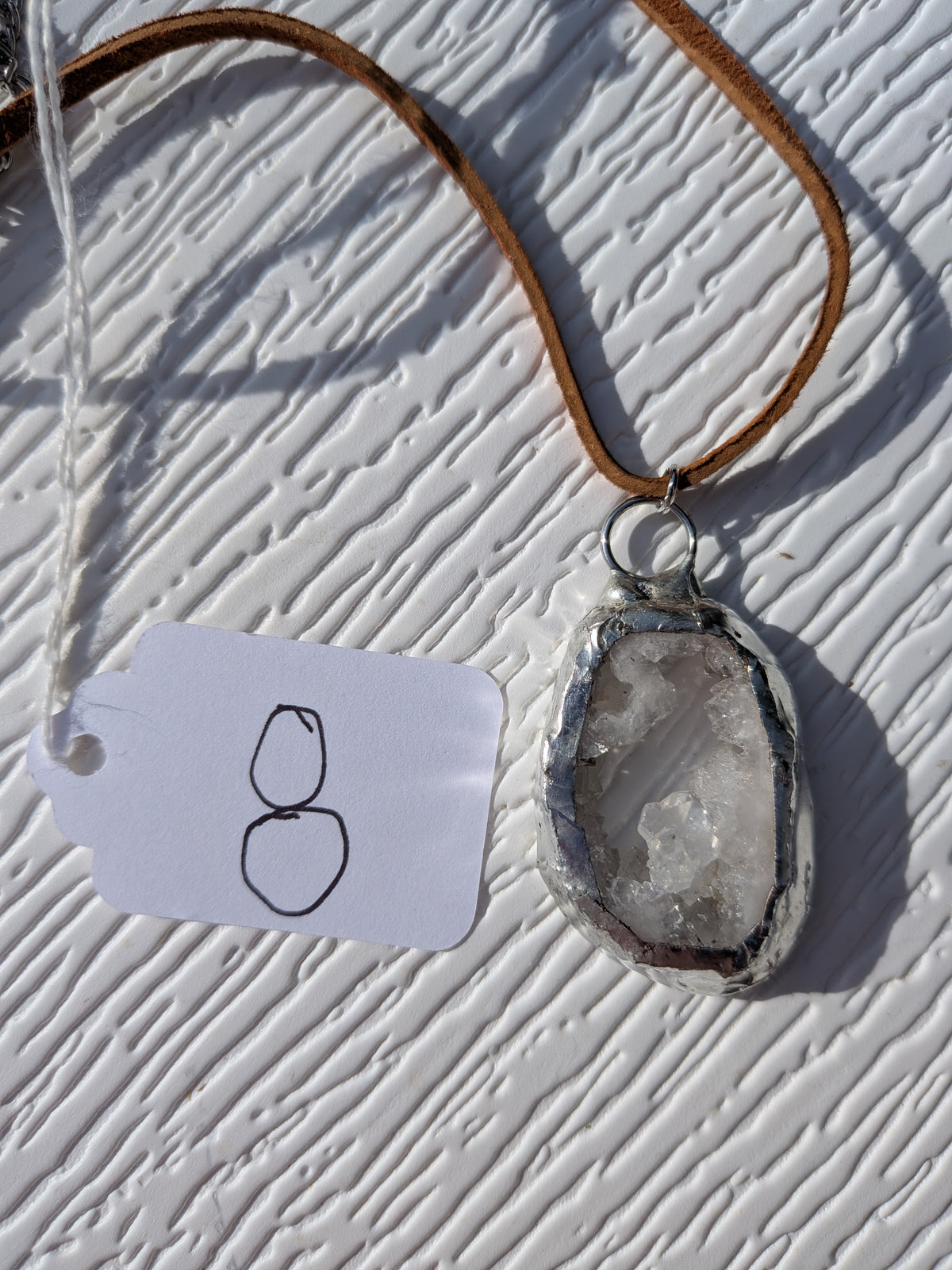 Back of Little Crystal Window geode necklace No. 008, showing the natural stone contours and handmade silver-tone edge.