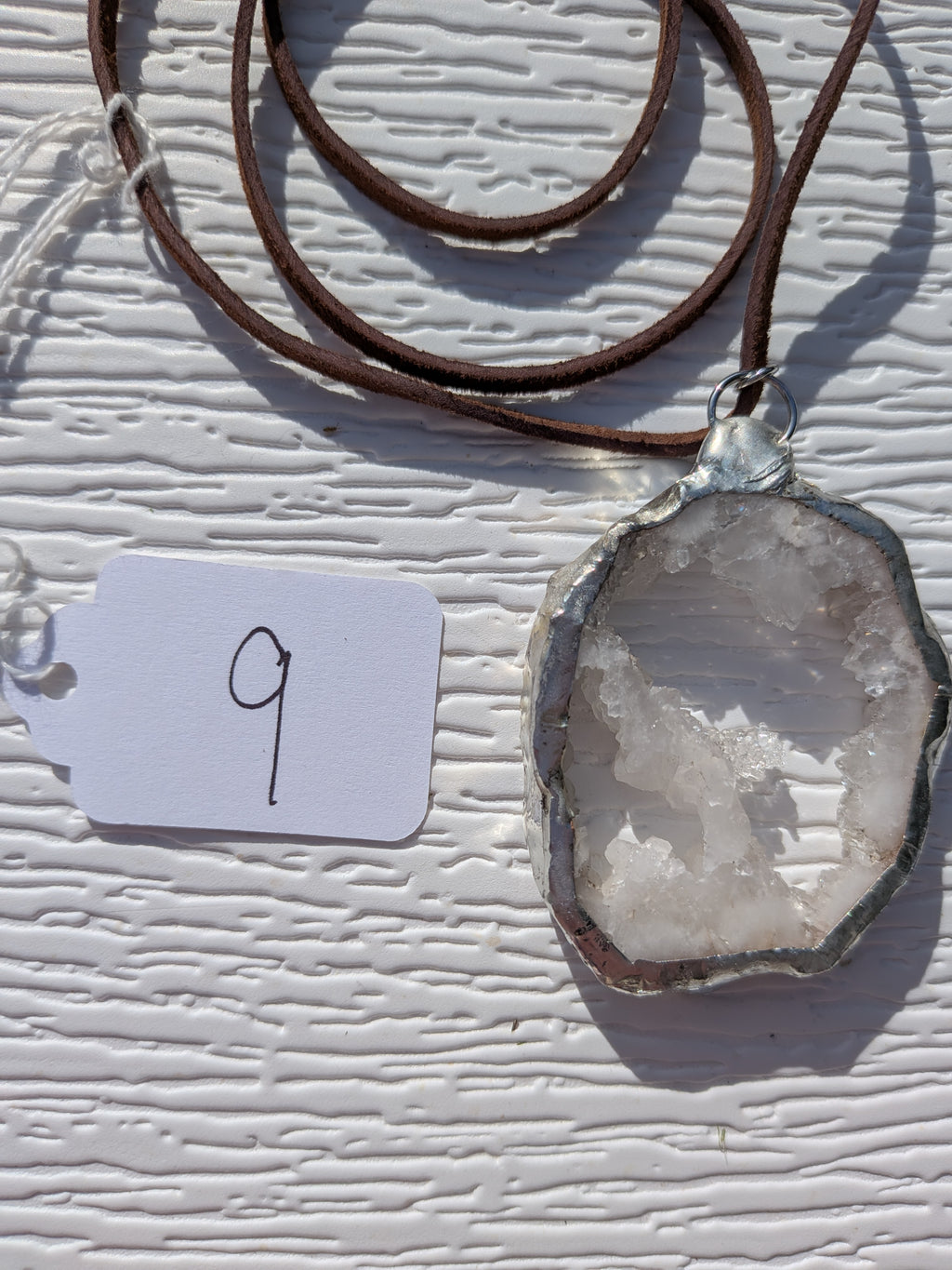 Back of Crystal Bridge geode necklace No. 009, showing the natural stone contours and handmade silver-tone edge.