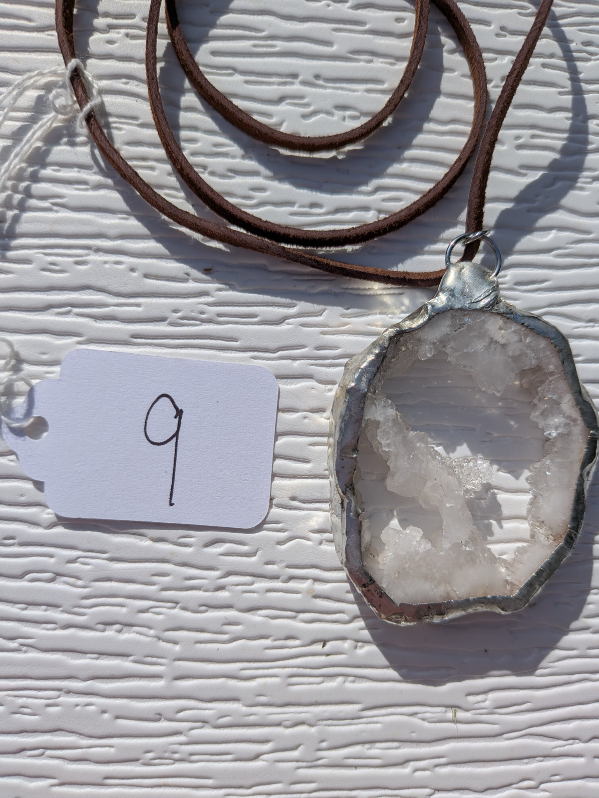 Back of Crystal Bridge geode necklace No. 009, showing the natural stone contours and handmade silver-tone edge.