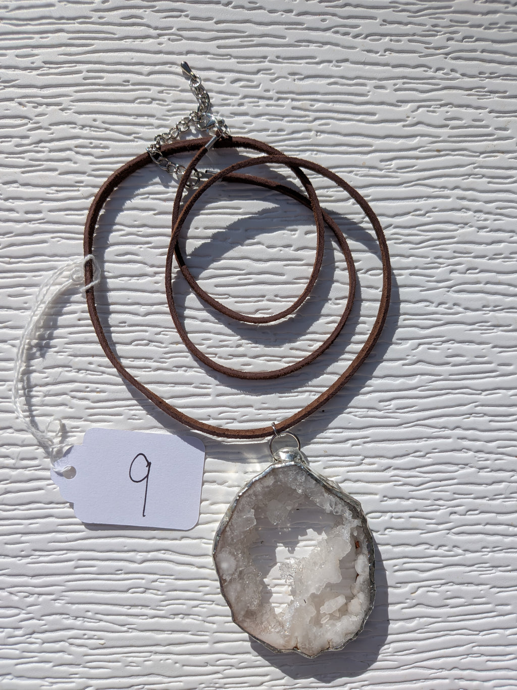 Full Crystal Bridge geode necklace No. 009, showing the pendant, dark brown cord, and clasp.